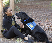 person sitting and smiling at Canine Companions service dog