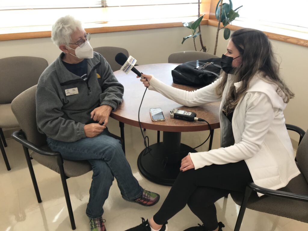 Woman with a microphone interviews a Canine Companions employee