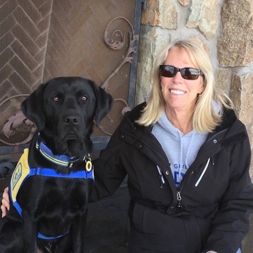 Volunteer puppy raiser Jan Peterson with black Canine Companions puppy