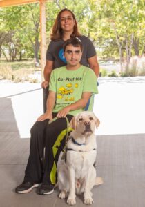 mother and son with yellow service dog