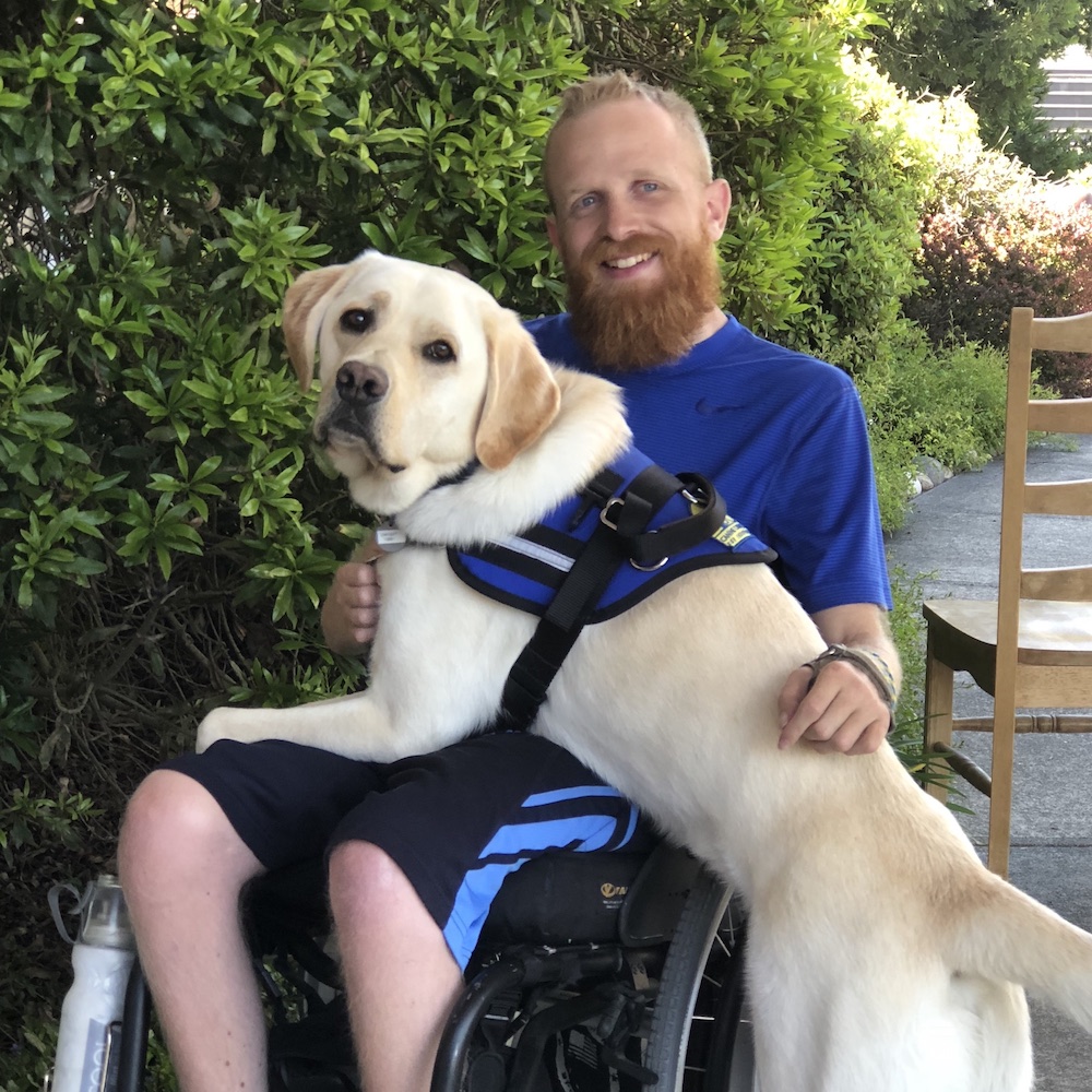 Volunteer and graduate Josiah Sullivan with his service dog, Dwight