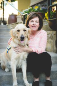 woman sitting with yellow golden puppy