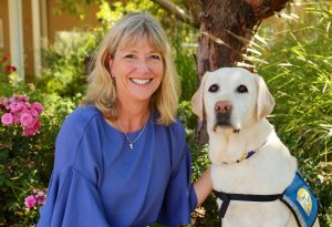 CEO Paige Mazzoni with a yellow Canine Companions service dog