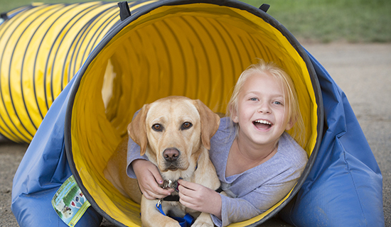 Girl with yellow dog in a tunnel