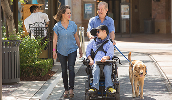 three people with Canine Companions service dog