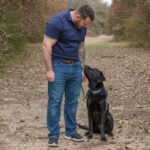 Canine Companions graduate looking at service dog by his side