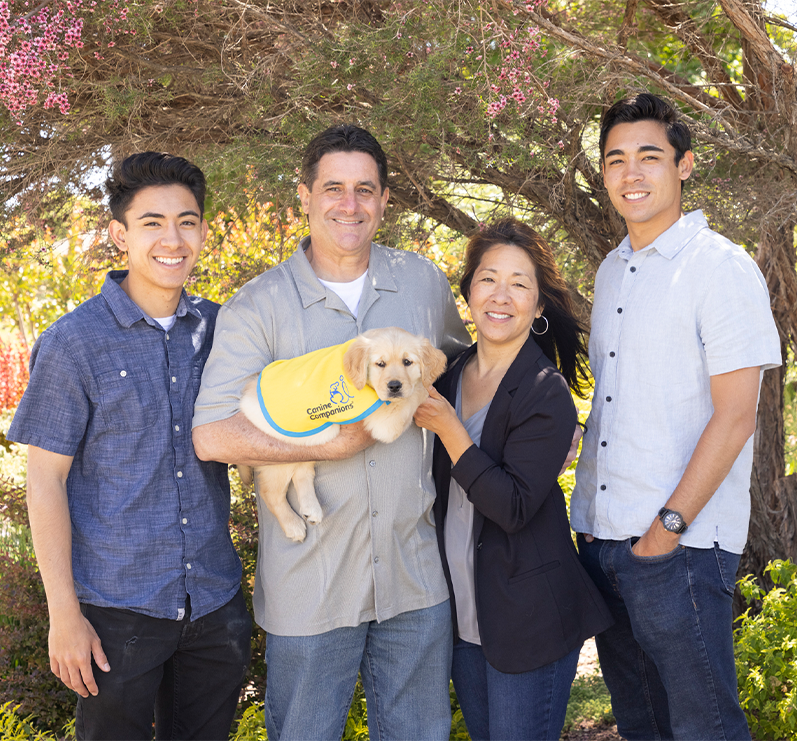 family of four holding canine companions puppy