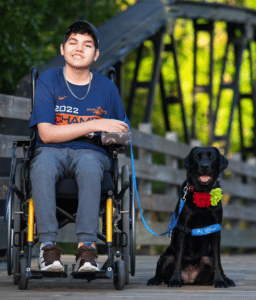 Boy in wheel chair with his service dog